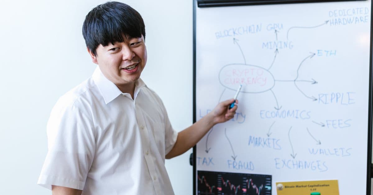 A professional explaining cryptocurrency concepts on a whiteboard during a seminar.