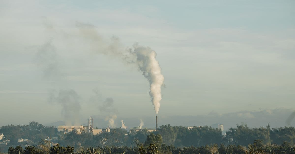 A smoke stack releasing emissions into the sky above Kon Tum, Vietnam, highlighting industrial impact.