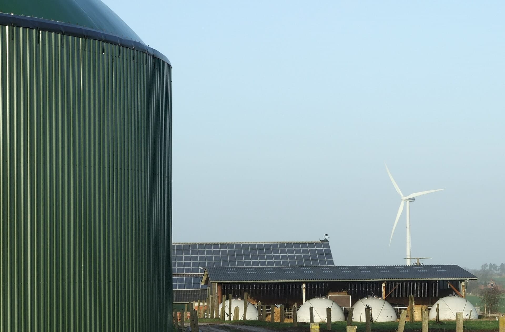A renewable-energy site combining biogas facilities, solar panels and a wind turbine.