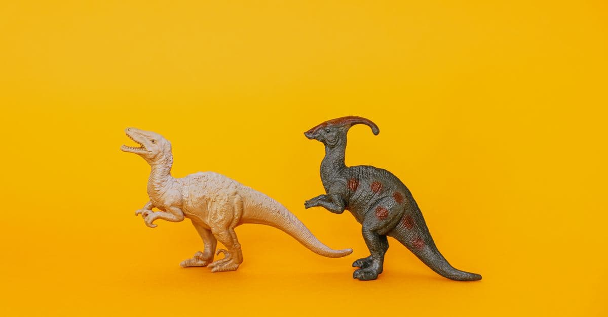 Two dinosaur toy figurines displayed against a vibrant yellow background, fostering imagination and play.