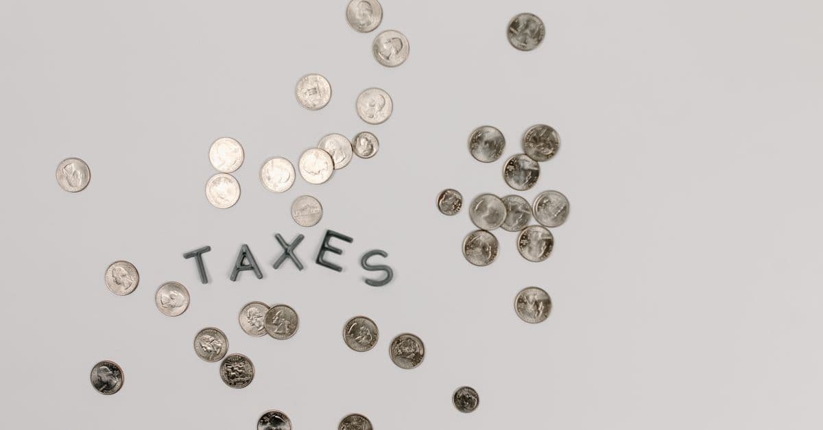 A visually striking flatlay of coins with 'Taxes' text on a white surface, ideal for financial concepts.