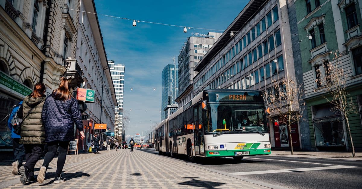 Street scene in Ljubljana featuring public transportation bus and pedestrians.