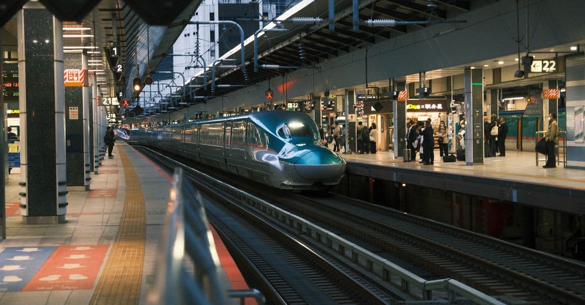 A sleek bullet train arrives at a busy Tokyo station, capturing urban transit energy.