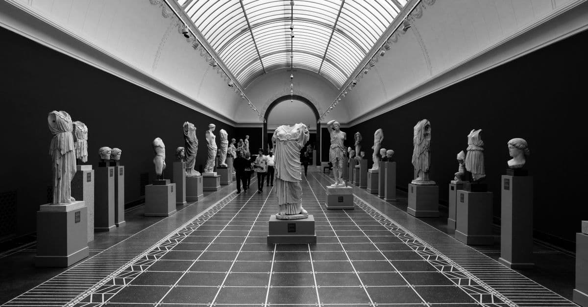 A captivating black and white view of sculptures in a Copenhagen museum hallway.