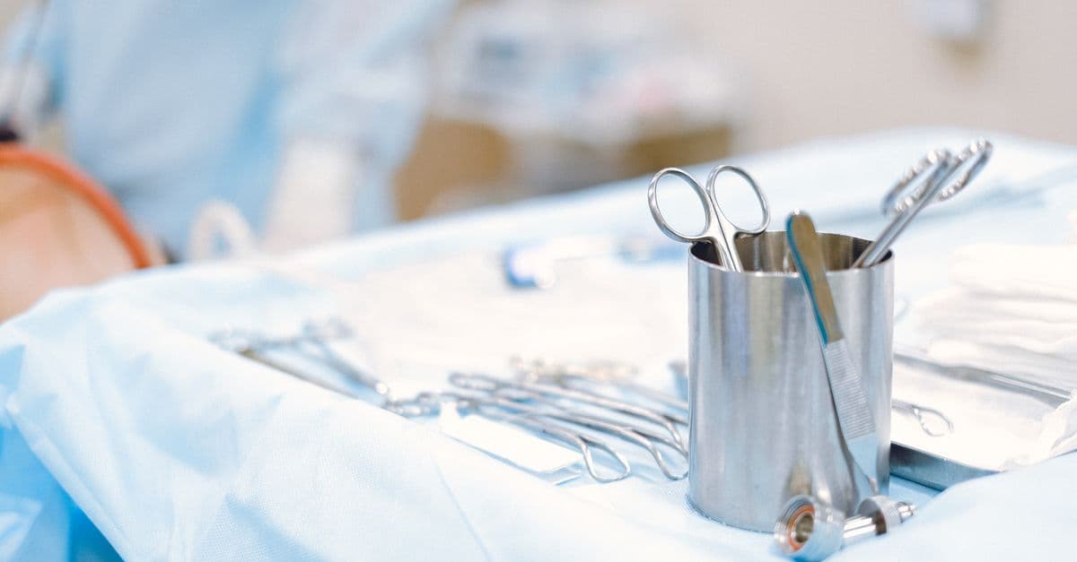 A close-up of surgical instruments on a sterile table in an operating room, emphasizing precision and care.