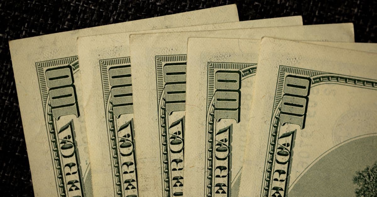 Detailed image of multiple one hundred dollar bills arranged in a stack.