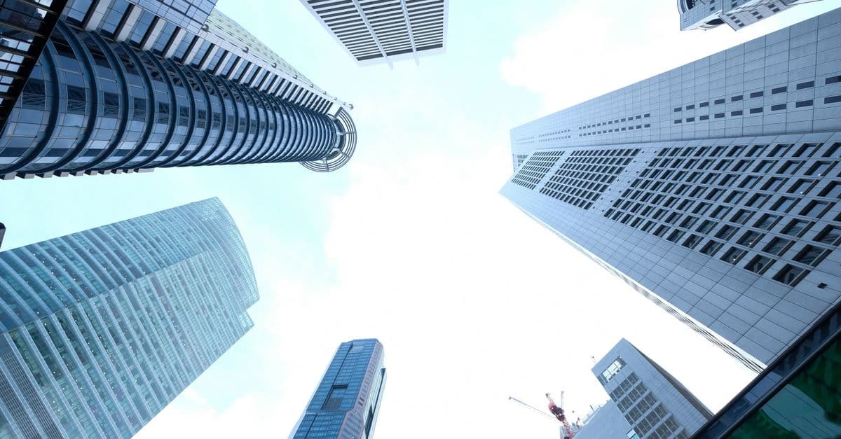 A striking upward view of various skyscrapers in an urban setting against a clear sky.