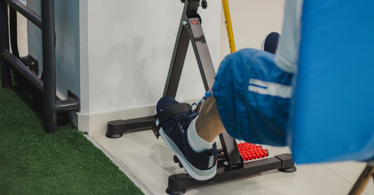 Close-up of a man working out on a stationary bike indoors, focusing on fitness and health.
