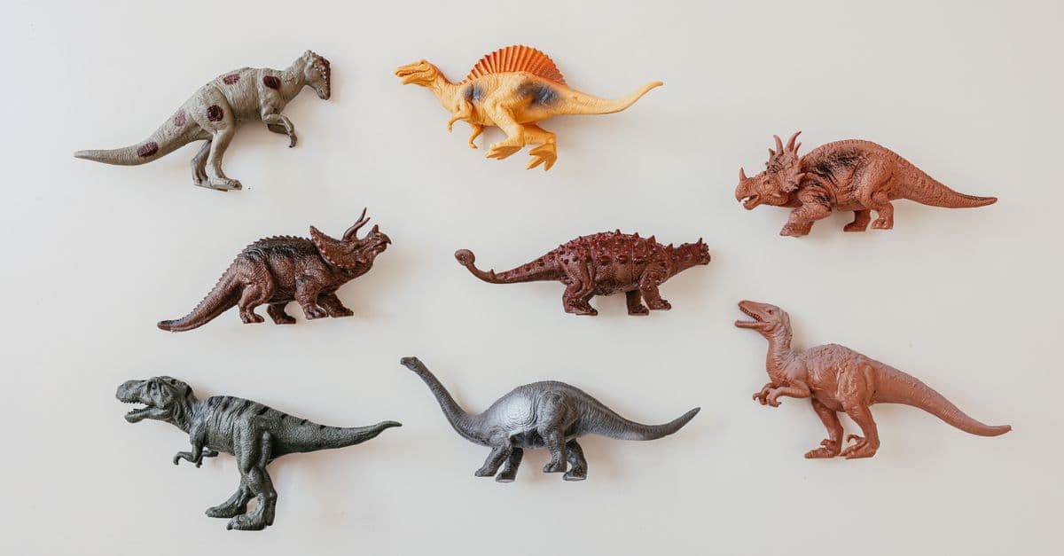 Colorful toy dinosaur models arranged on a white background. Perfect for educational and playful themes.