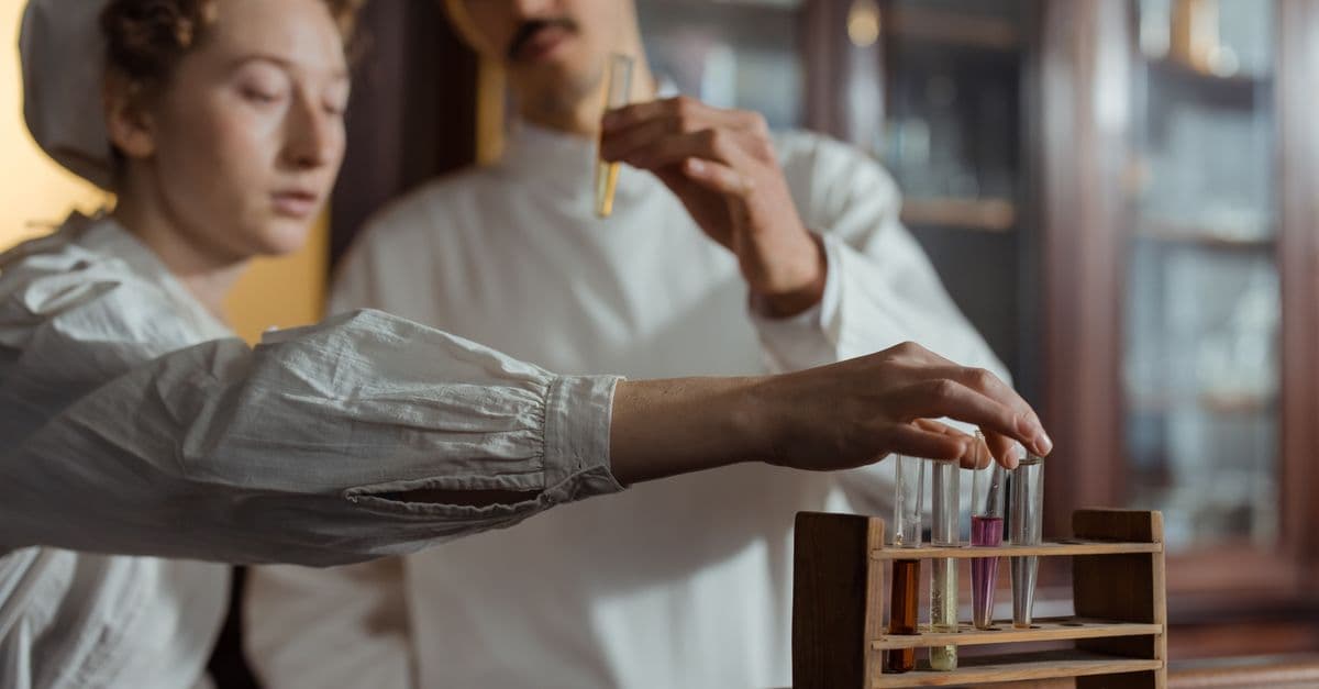 Researchers in a lab examining test tubes with colored liquids for experiments.