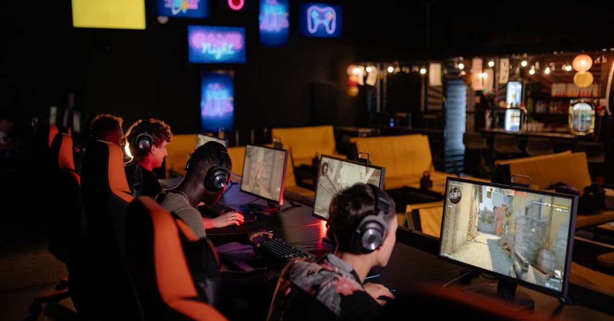 Group of gamers participating in an online tournament at a modern internet cafe.