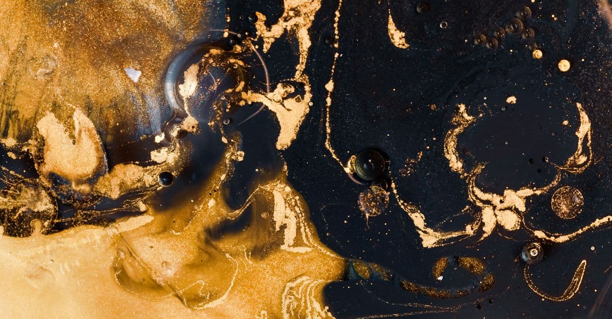 Mesmerizing abstract pattern of swirling black and gold with metallic shimmer and texture.