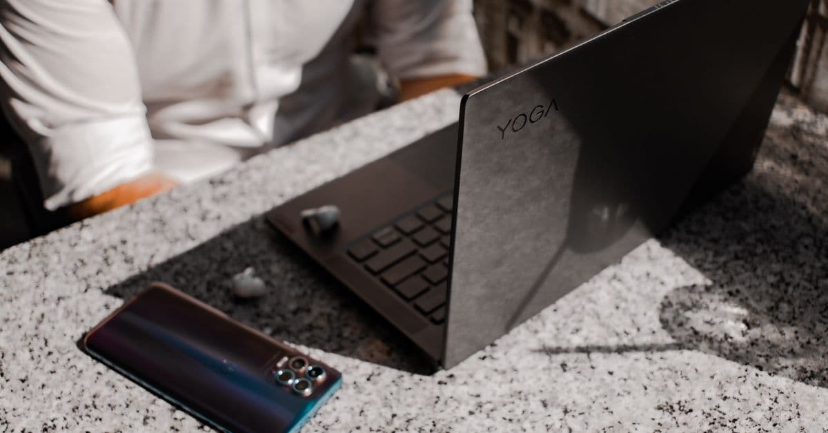 A sleek laptop and smartphone placed on a granite table outdoors, perfect for remote working.