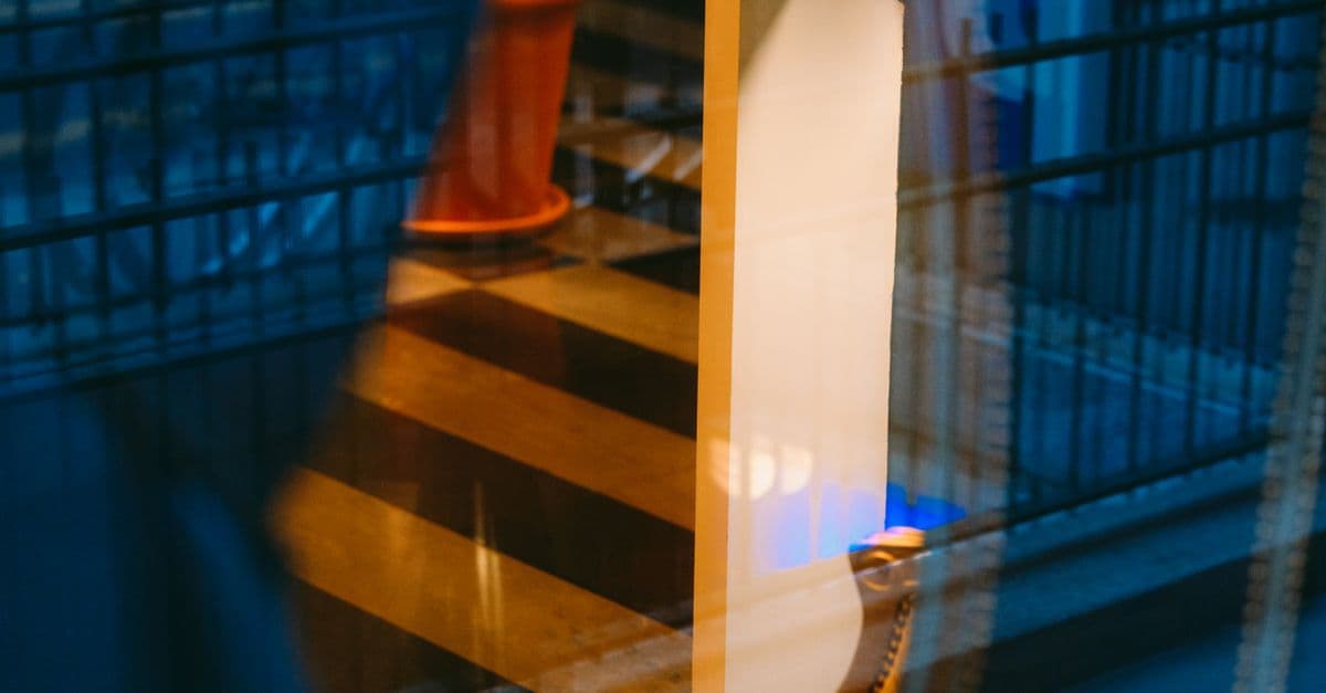 Abstract reflection of urban architecture through a window pane with orange accents.