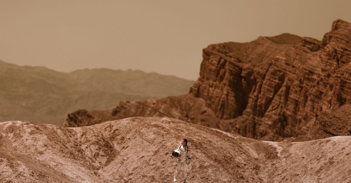 A woman astronaut stands on a barren, alien terrain, symbolizing space colonization.