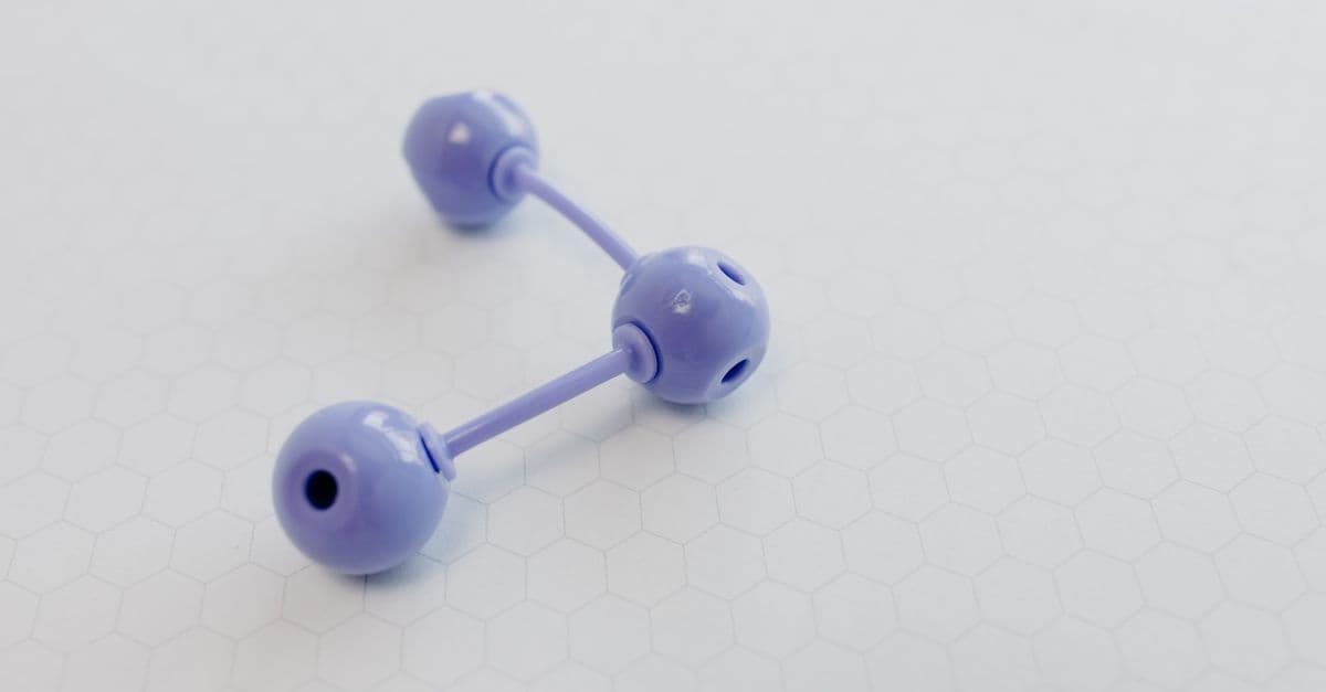 Abstract representation of a molecular structure using a purple plastic model on hexagonal patterned paper.