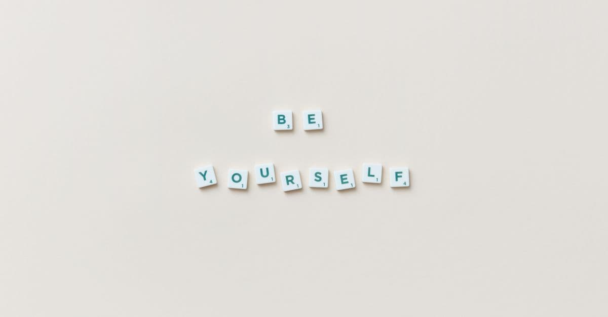 Motivational phrase "Be Yourself" spelled with letter tiles on a white background.