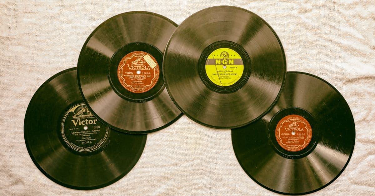A collection of classic vintage vinyl records displayed on a textured background, evoking nostalgia and musical history.