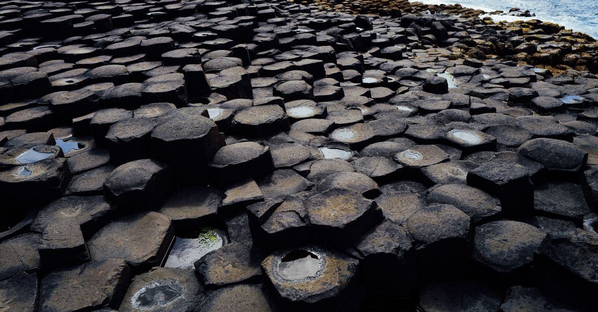 Explore the unique interlocking basalt columns of the Giant's Causeway by the rugged coastline.