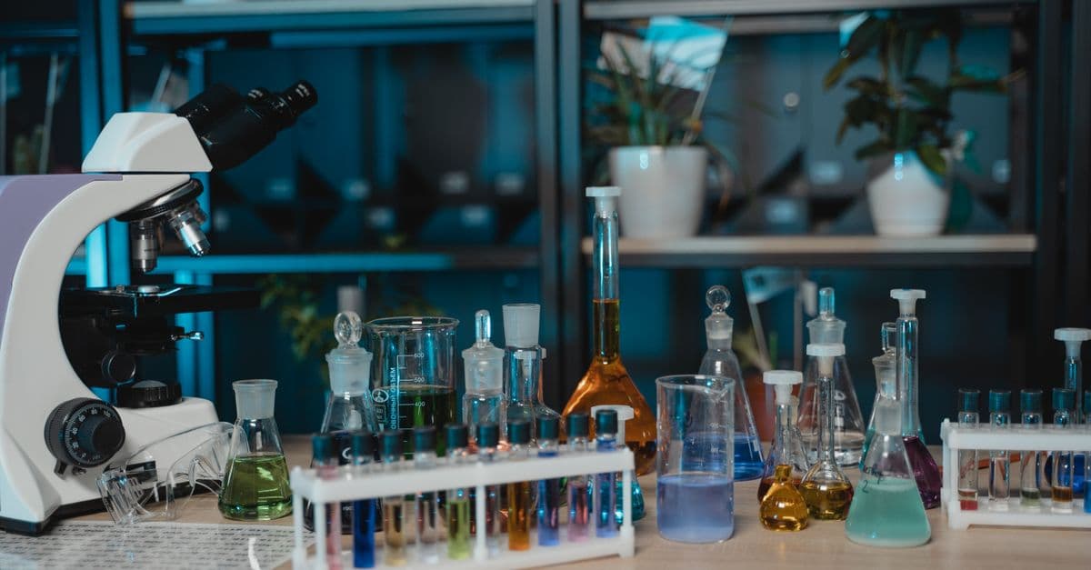 Vibrant laboratory setup with glassware, colored liquids, and a microscope for scientific research.