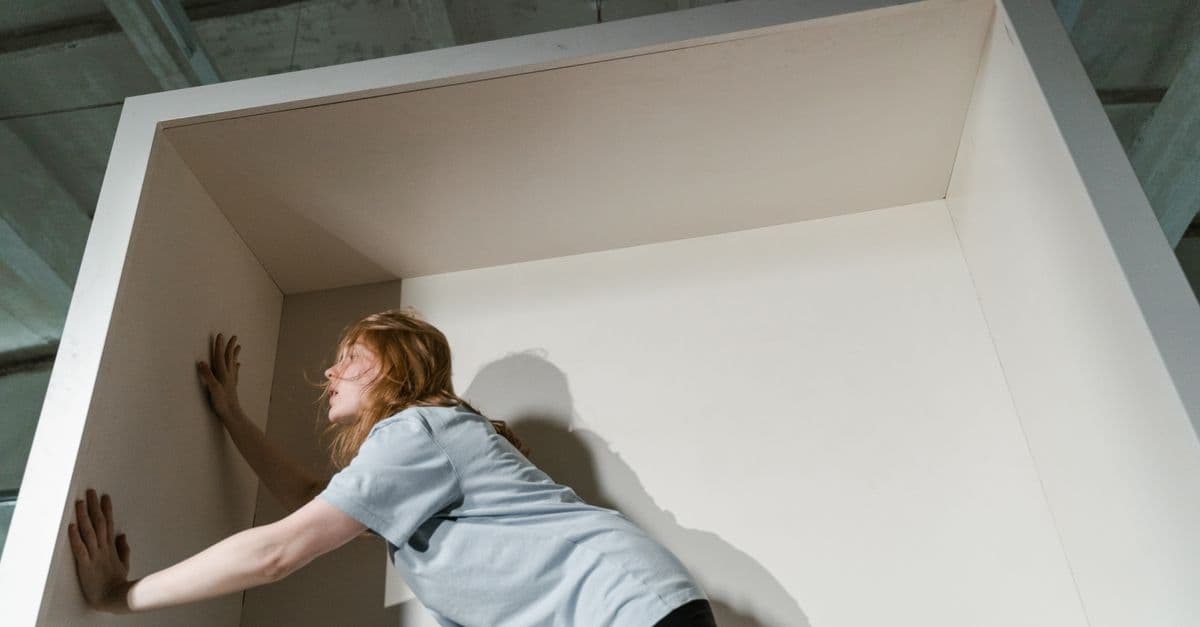 A woman feeling claustrophobic, trapped in a confined box, symbolizing anxiety and fear.