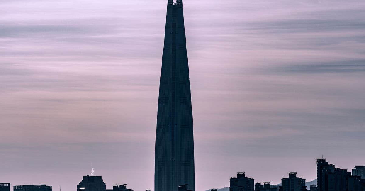 Silhouette of the Lotte World Tower in Seoul against a dusky sky, highlighting urban architecture.