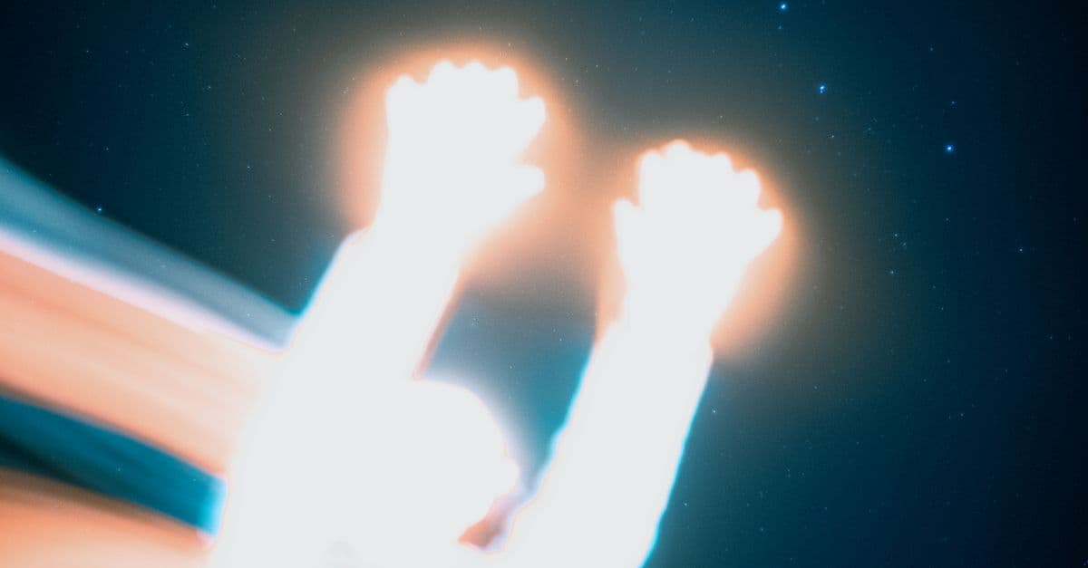 Creative long exposure shot featuring abstract light painting and a starry sky backdrop.