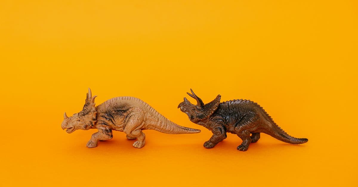 Triceratops and dinosaur toy models displayed against a bold yellow backdrop, creating a prehistoric theme.