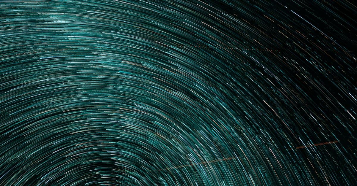 Dynamic turquoise star trails creating a swirling vortex in a captivating abstract pattern.