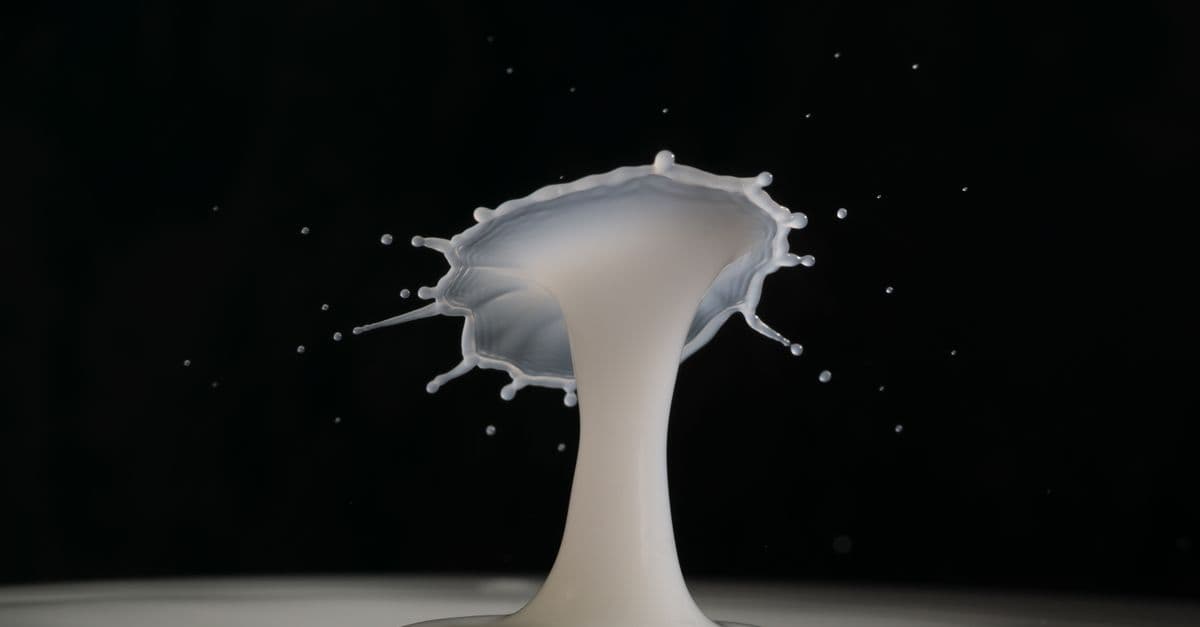 Captivating close-up of milk splash in motion, creating an artistic pattern against a dark backdrop.