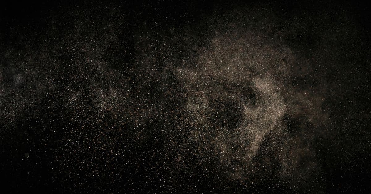 Abstract image of fine particles floating against a black background.