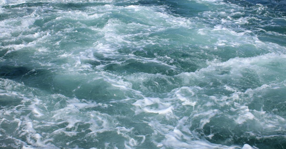 Close-up view of ocean waves with frothy white sea foam, capturing movement.