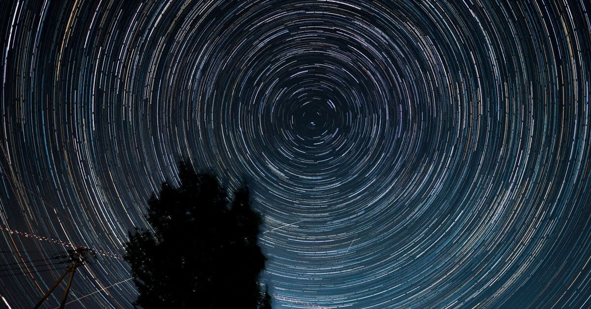 Captivating long exposure shot of star trails spiraling across the night sky.