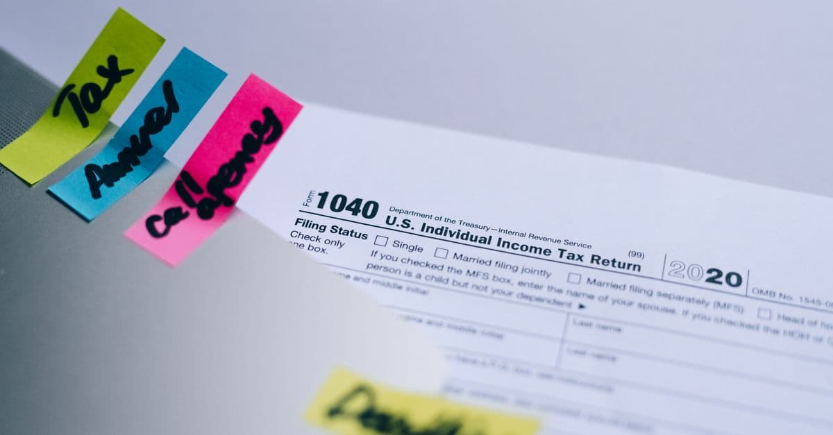 Close-up of 1040 U.S. tax form with colorful sticky notes for organization.