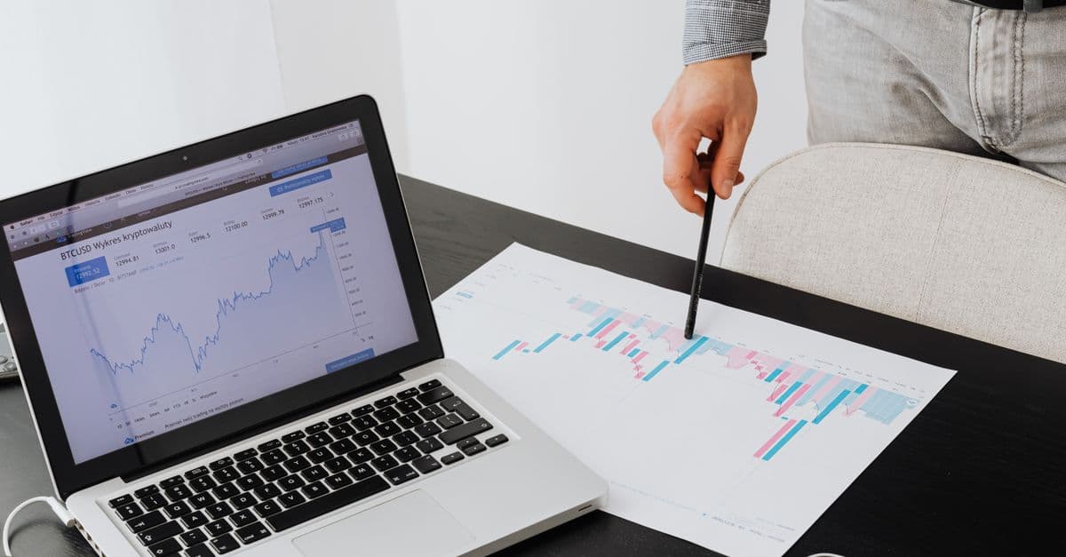 Person analyzing cryptocurrency data using a laptop, highlighting financial insights.