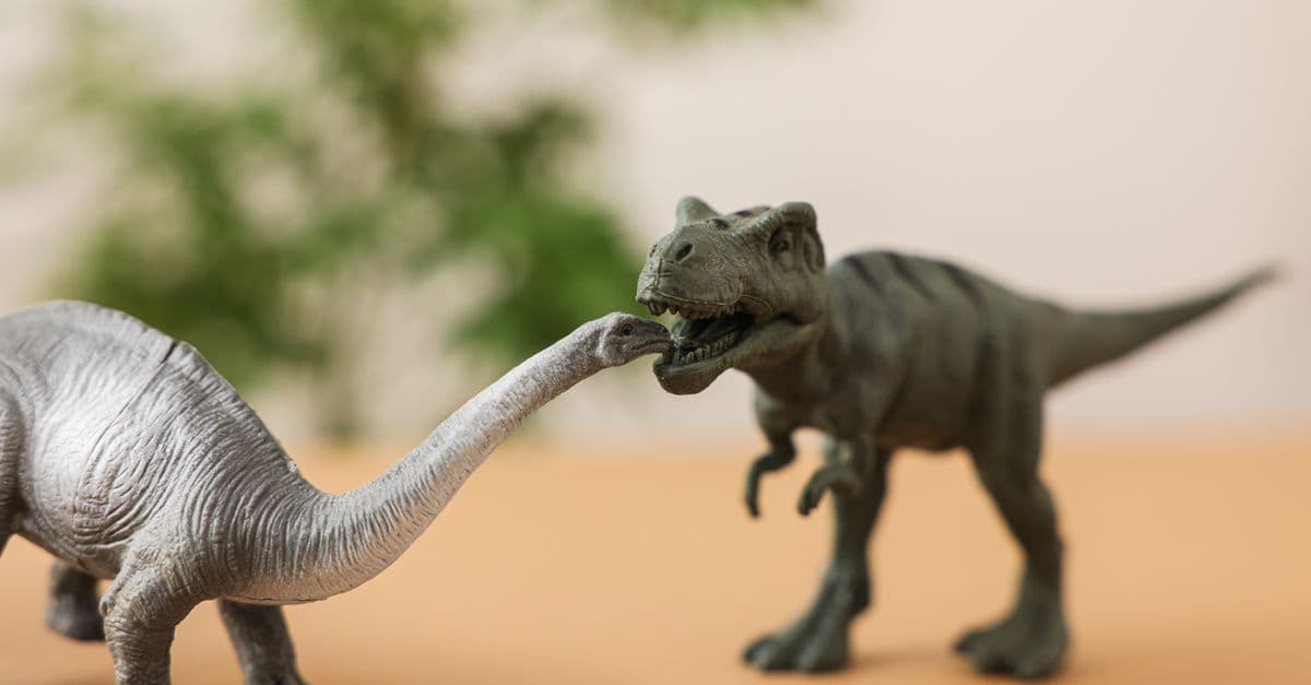 Close-up of toy dinosaurs in a playful scene with a blurred background.
