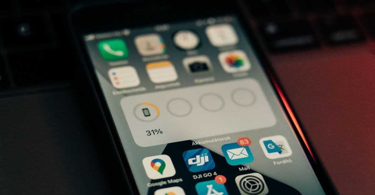 A smartphone with various apps on its screen placed on a keyboard, showing a 31% battery level.