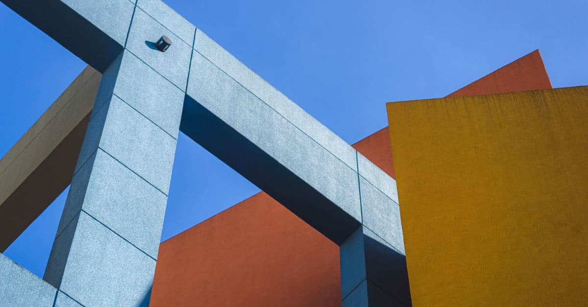 Dynamic shot of colorful geometric architecture against clear blue sky.