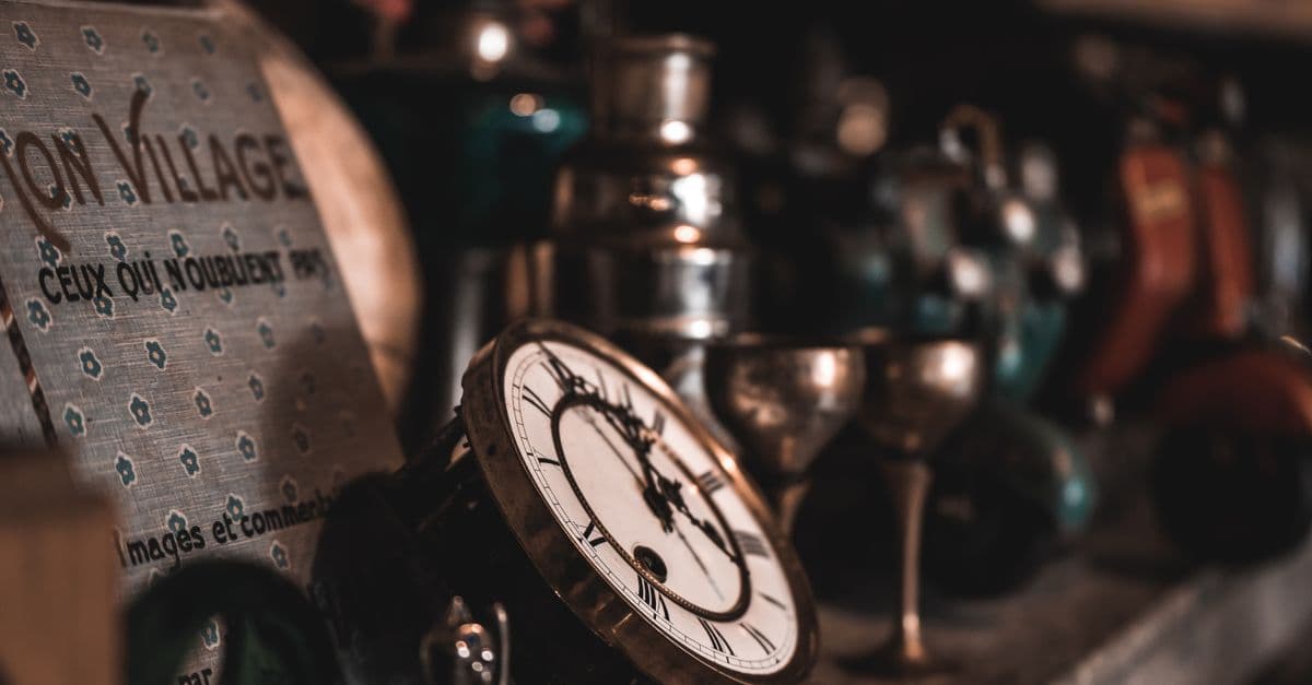 A close-up view of vintage clocks and antique items on a shelf, creating a nostalgic feel.