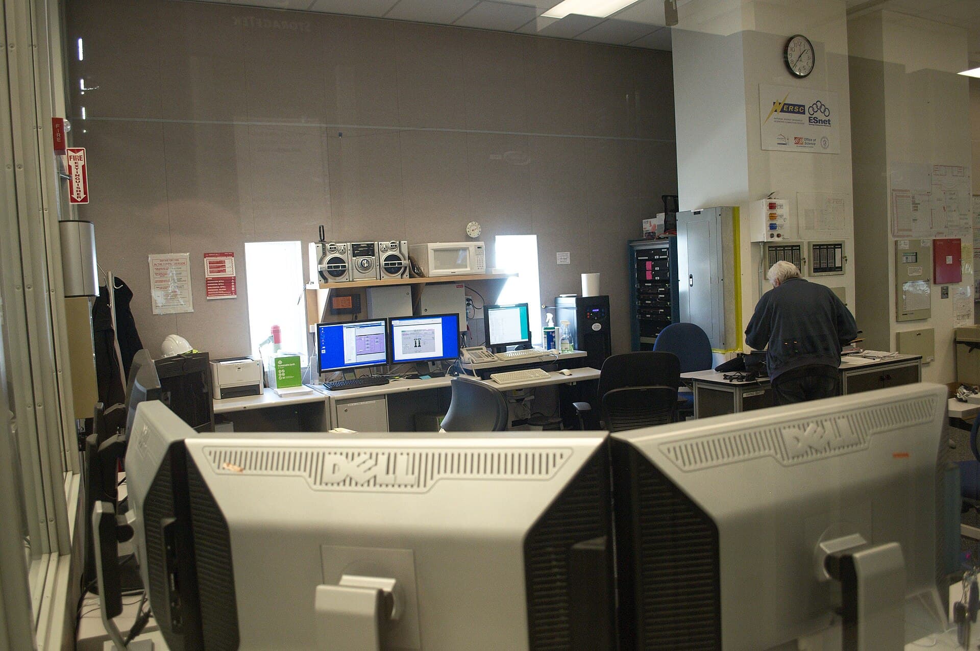 Technicians working in a data-center monitoring room, illustrating operational observability for AI systems.