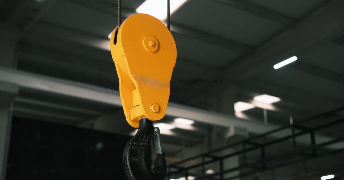 Close-up view of a yellow crane hook in an industrial factory setting in Konya, Türkiye.