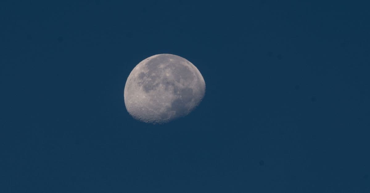 Crescent moon captured in a serene twilight sky, highlighting lunar details.