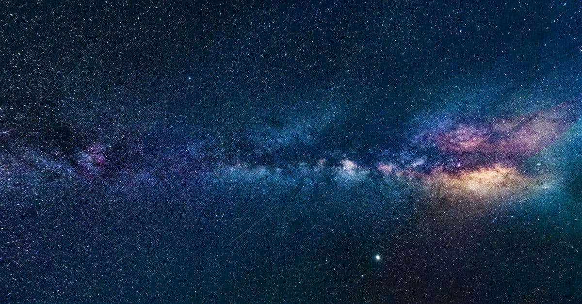 Capture of the Milky Way galaxy stretching across the dark night sky, filled with stars.