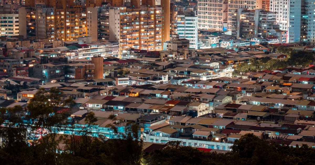 A dynamic aerial view of a bustling cityscape with illuminated buildings at night.
