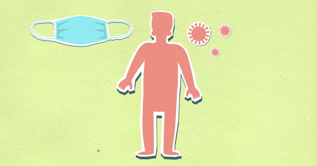 Decorative cardboard illustration of human figure between sterile mask and viruses during coronavirus pandemic on green background