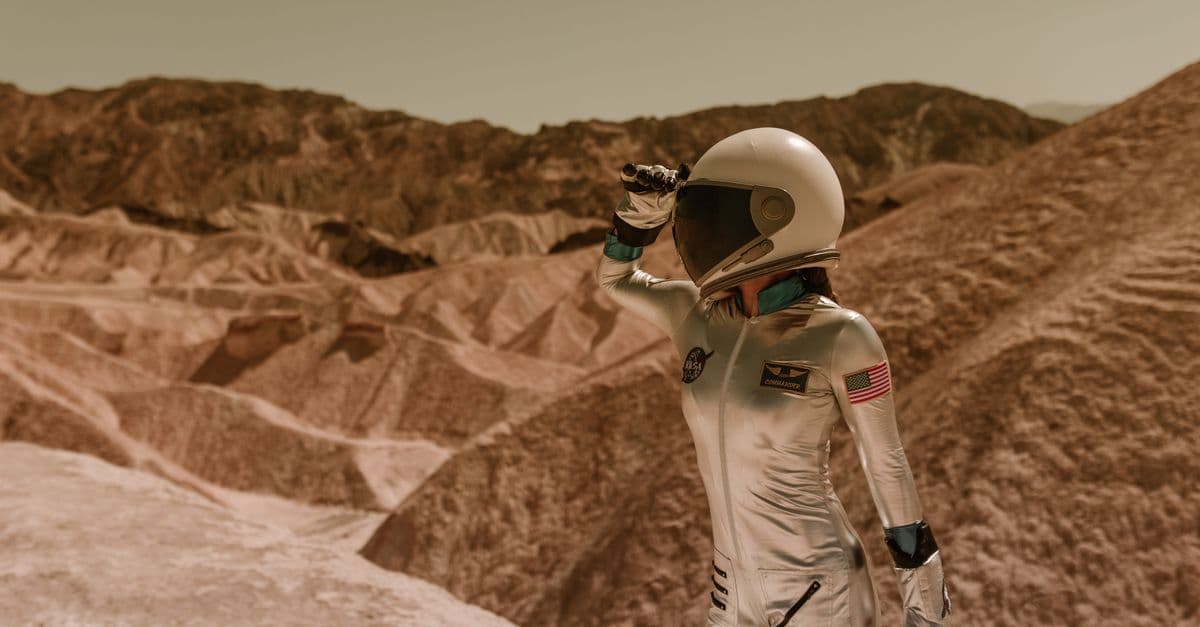 A woman in an astronaut suit exploring a barren, rocky desert landscape, evoking a space exploration theme.