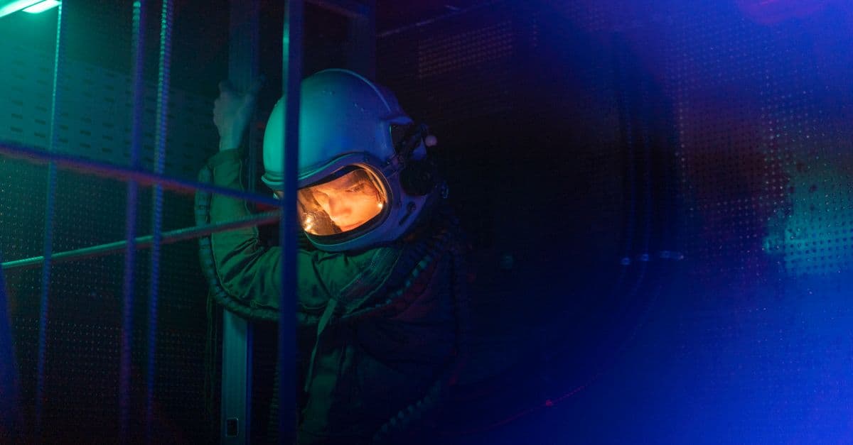 Portrait of a female astronaut in space suit with dramatic blue lighting and futuristic setting.