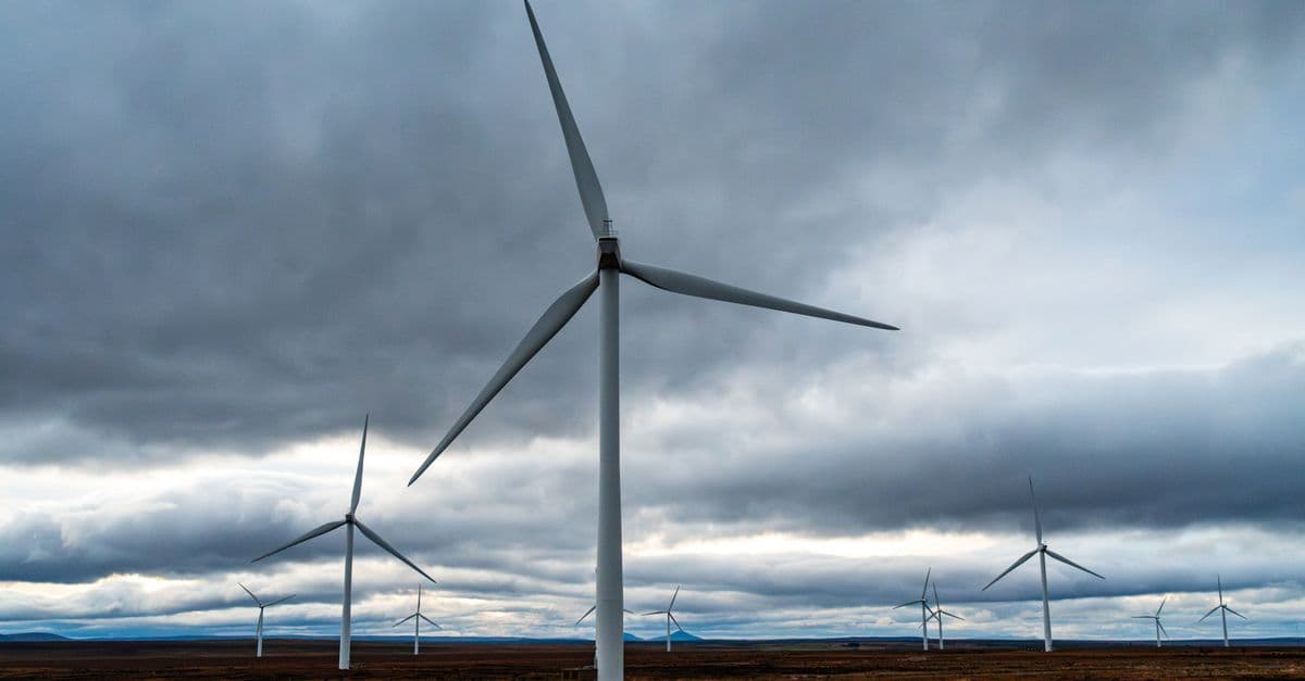 Vast wind farm with turbines harnessing wind energy under dramatic skies.