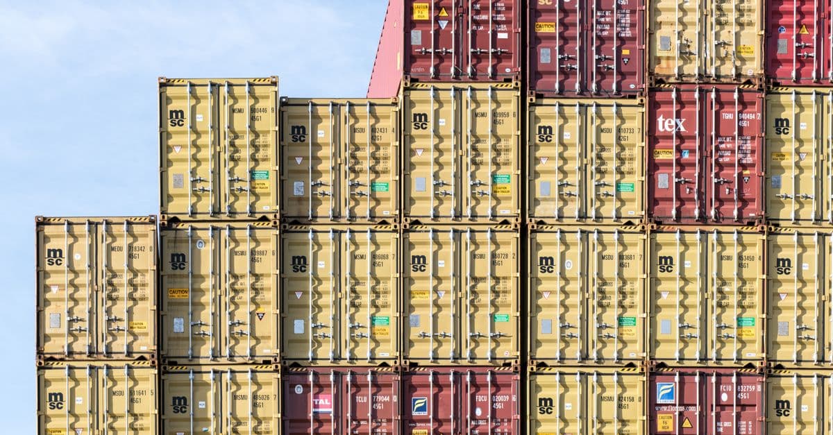 Colorful stacked shipping containers at a seaport representing global crude-oil trade and energy logistics.