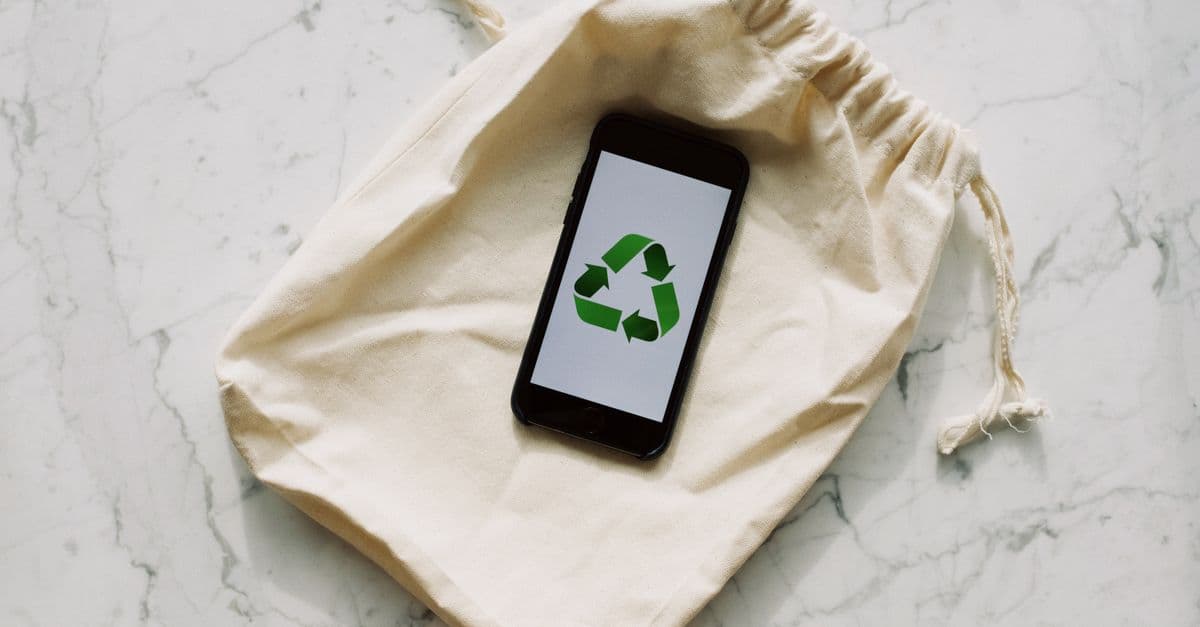 Smartphone displaying recycling icon on a drawstring pouch. Eco-conscious and sustainable theme.